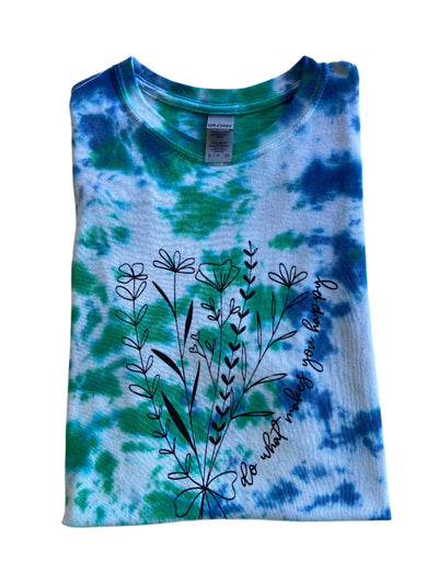 Folded Blue, Green and White short sleeve tie-dye t-shirt with a floral image and cursive test "Do What Makes You Happy"